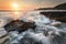 waves splashing around rocks at sunrise on nsw south coast of australia