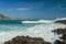 Waves splashing on a headland around Tanjung Aan beach. Dangerous phenomenon on a heavenly beach. Water is bubbled from the