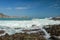 Waves splashing on sharp cliffs of Tanjung Aan beach. Dangerous phenomenon on a heavenly beach. Water is bubbled from the strength