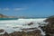 Waves splashing on sharp cliffs of Tanjung Aan beach. Dangerous phenomenon on a heavenly beach. Water is bubbled from the strength