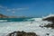 Waves splashing on sharp cliffs of Tanjung Aan beach. Dangerous phenomenon on a heavenly beach. Water is bubbled from the strength