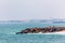 Waves, stones at the coastline with houses in background, Swakopmund German colonial town, Namibia