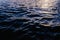 Waves on the surface of the sea water at dusk with compact, solid and deeply calm texture