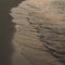 Waves wash over golden sand on beach