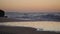 Waves wash over the sandy beach. Water is absorbed into the sand.