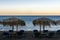 Waves and wind on the beach with umbrellas and sunbeds, lounge chairs on sunset