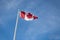 Waving Canadian flag against the blue sky.
