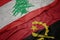 waving colorful flag of angola and national flag of lebanon