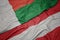 waving colorful flag of austria and national flag of madagascar