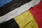 waving colorful flag of belgium and national flag of estonia