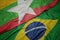 waving colorful flag of brazil and national flag of myanmar