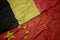 waving colorful flag of china and national flag of belgium