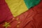 waving colorful flag of china and national flag of guinea