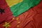 waving colorful flag of china and national flag of guinea bissau
