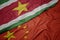 waving colorful flag of china and national flag of suriname