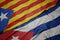 waving colorful flag of cuba and national flag of catalonia