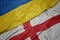 waving colorful flag of england and national flag of ukraine