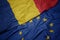 Waving colorful flag of european union and national flag of romania