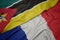 waving colorful flag of france and national flag of mozambique