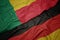 waving colorful flag of germany and national flag of benin