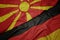 waving colorful flag of germany and national flag of macedonia