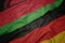 waving colorful flag of germany and national flag of malawi