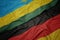 waving colorful flag of germany and national flag of rwanda