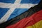 waving colorful flag of germany and national flag of scotland