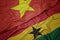 waving colorful flag of ghana and national flag of vietnam