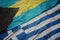 waving colorful flag of greece and national flag of bahamas