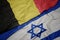 waving colorful flag of israel and national flag of belgium