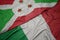 waving colorful flag of italy and national flag of burundi