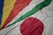 waving colorful flag of japan and national flag of seychelles