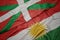 waving colorful flag of kurdistan and national flag of basque country
