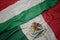 Waving colorful flag of mexico and national flag of hungary.