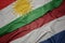 waving colorful flag of netherlands and national flag of kurdistan