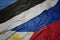 waving colorful flag of philippines and national flag of estonia