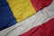 waving colorful flag of poland and national flag of romania