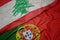 waving colorful flag of portugal and national flag of lebanon