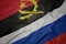 waving colorful flag of russia and national flag of angola