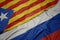 waving colorful flag of russia and national flag of catalonia