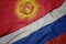 waving colorful flag of russia and national flag of kyrgyzstan