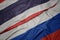 waving colorful flag of russia and national flag of thailand