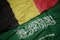 waving colorful flag of saudi arabia and national flag of belgium