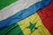 waving colorful flag of senegal and national flag of sierra leone