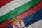 waving colorful flag of serbia and national flag of hungary