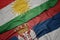 waving colorful flag of serbia and national flag of kurdistan