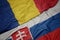 waving colorful flag of slovakia and national flag of romania