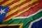 waving colorful flag of south africa and national flag of catalonia