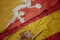 waving colorful flag of spain and national flag of bhutan